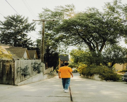 Person walking on a quiet urban street with a casual rhythm